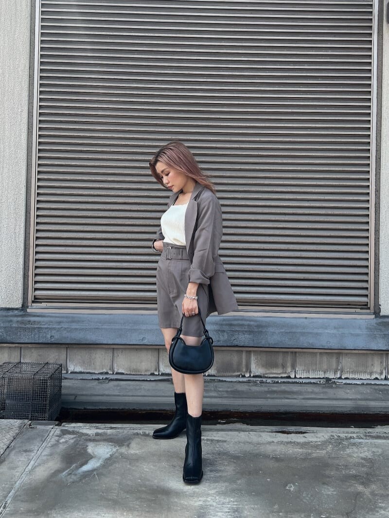 ホワイト系のタンクトップ、グレー系のテーラードジャケット、グレー系のスカートを着用したレディースの夏コーディネートの2枚目の写真