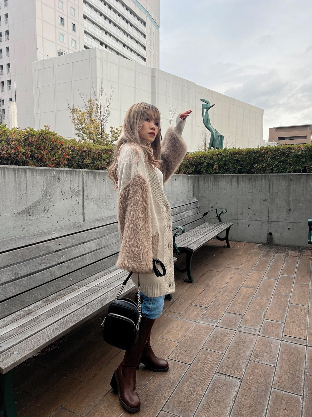 ホワイト系のニット/セーター、ベージュ系のカーディガン/ボレロ、ブラウン系のブーツを着用したレディースの冬コーディネートの4枚目の写真