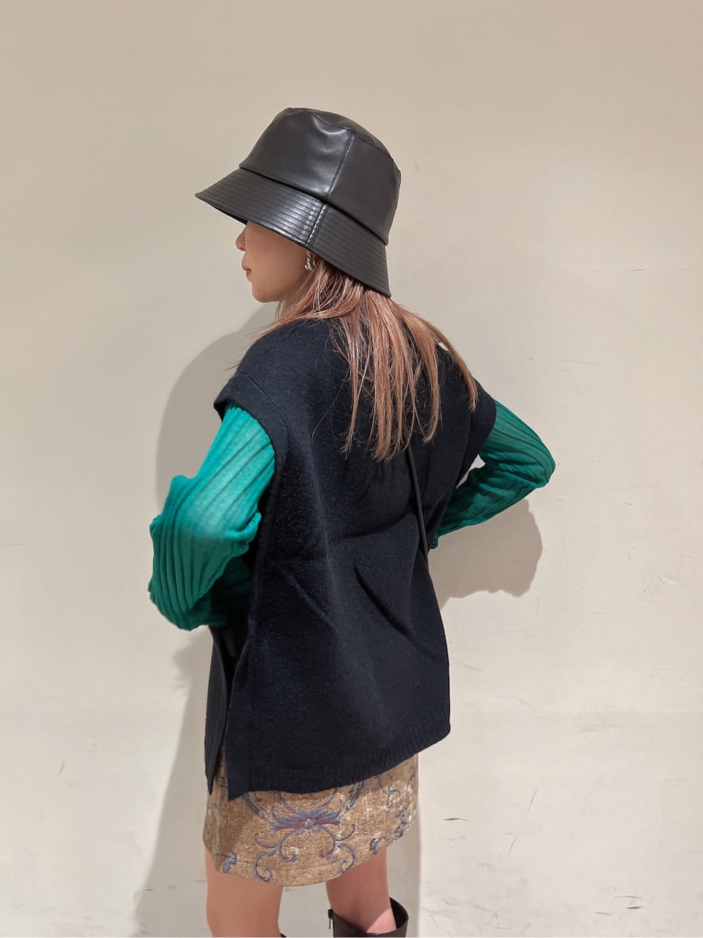 ブラック系のブーツ、グリーン系のニット/セーター、ブラウン系のスカートを着用したレディースの秋コーディネートの5枚目の写真