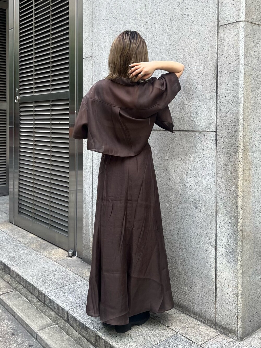 ブラック系のブーツ、その他のニット/セーター、ブラウン系のスカートを着用したレディースの夏コーディネートの3枚目の写真