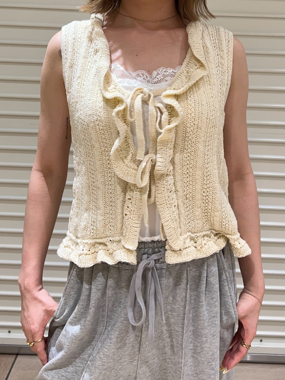 ホワイト系のニット/セーター、グレー系のスウェットパンツを着用したレディースの夏コーディネートの5枚目の写真