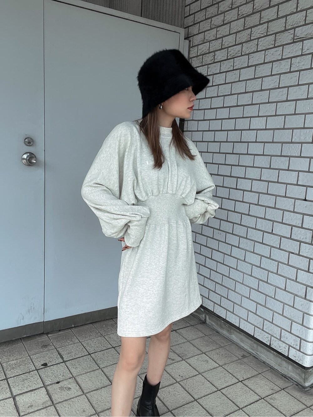 ホワイト系のワンピース、ブラック系のブーツ、ブラック系のブルゾンを着用したレディースの秋コーディネートの5枚目の写真