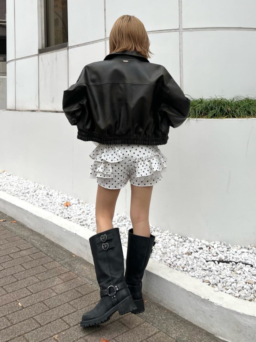 ブラック系のブーツ、ホワイト系のその他パンツ、ブラック系のTシャツ/カットソーを着用したレディースの冬コーディネートの2枚目の写真