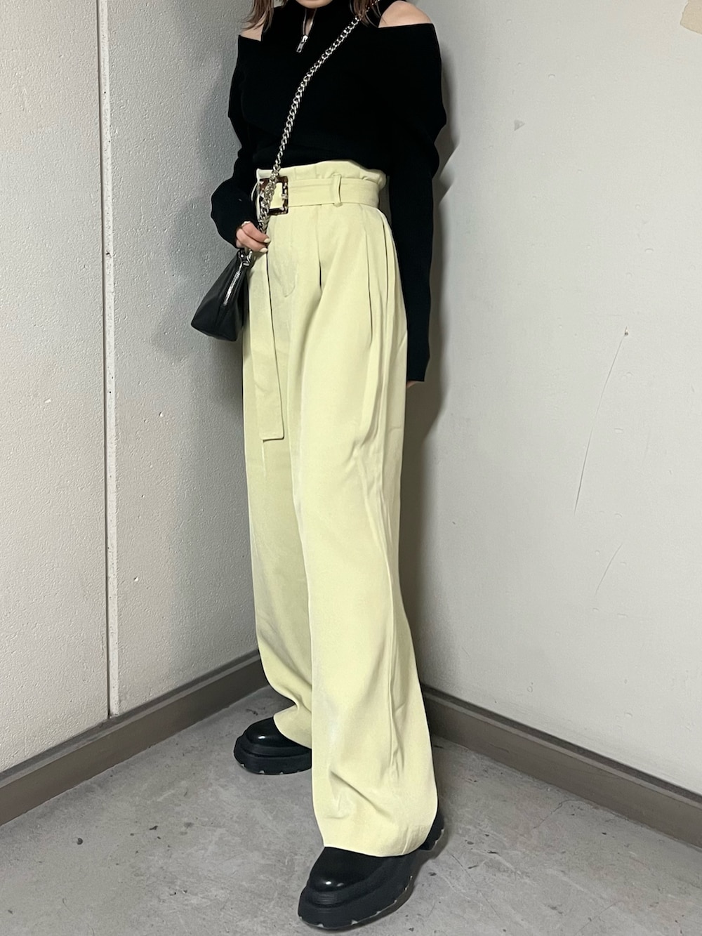 ブラック系のニット/セーター、ブラック系のハンドバッグ、ブラック系のブーツを着用したレディースの冬コーディネートの6枚目の写真