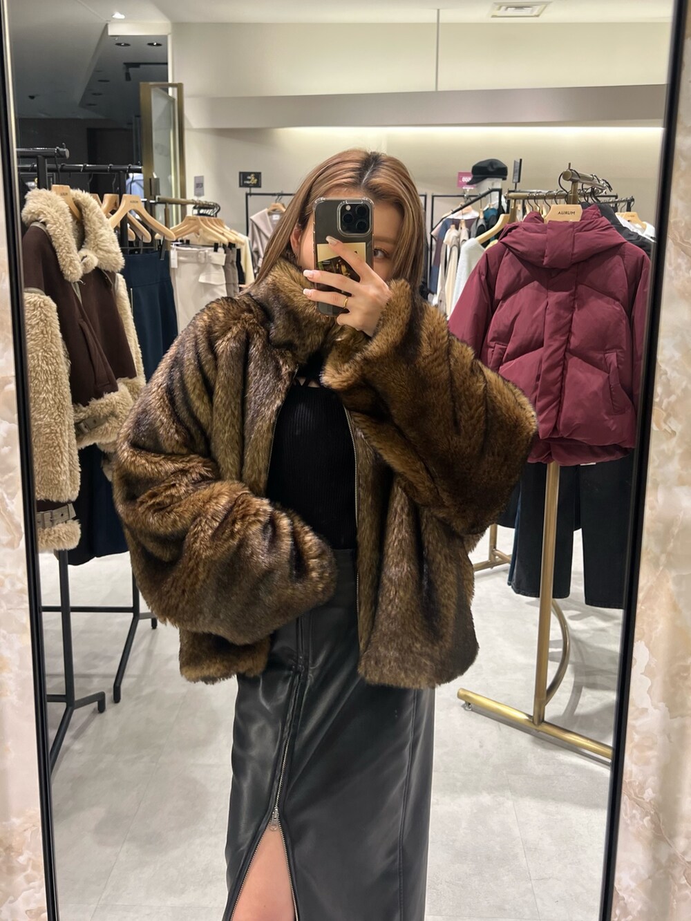 ブラック系のスカート、ブラウン系のブルゾン、ブラック系のニット/セーターを着用したレディースの冬コーディネートの2枚目の写真