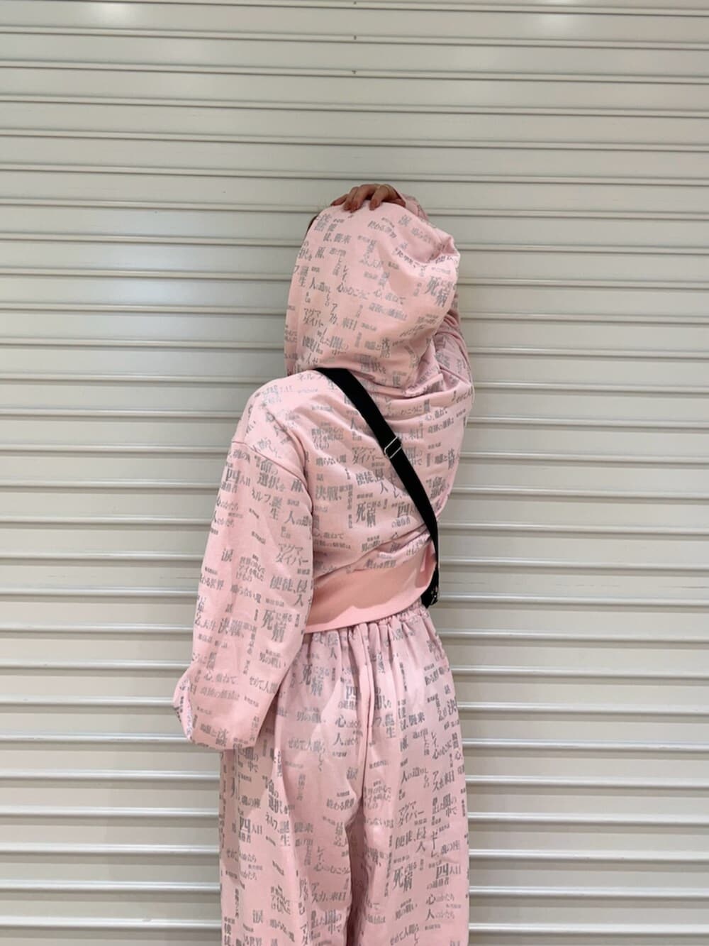 ピンク系のセットアップ、ブラック系のショルダーバッグを着用したレディースの春コーディネートの5枚目の写真