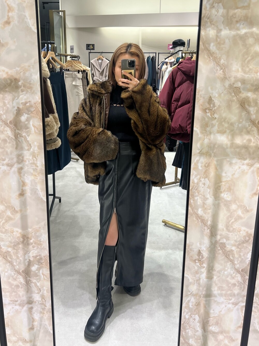 ブラック系のスカート、ブラウン系のブルゾン、ブラック系のニット/セーターを着用したレディースの冬コーディネートの5枚目の写真