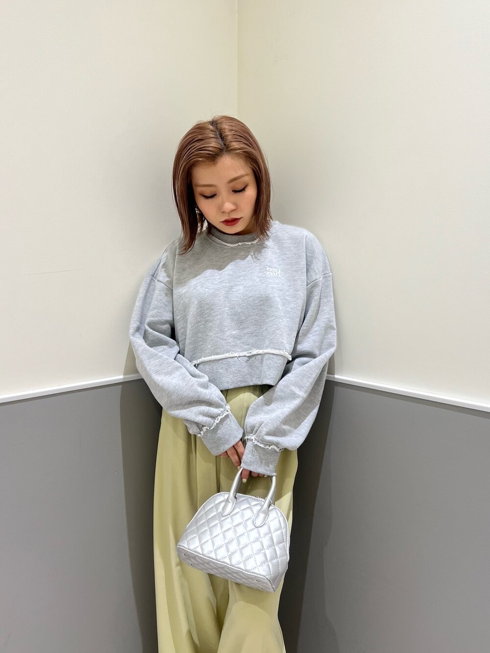 グレー系のスウェット、グリーン系のその他パンツ、シルバー系のハンドバッグを着用したレディースの冬コーディネートの4枚目の写真