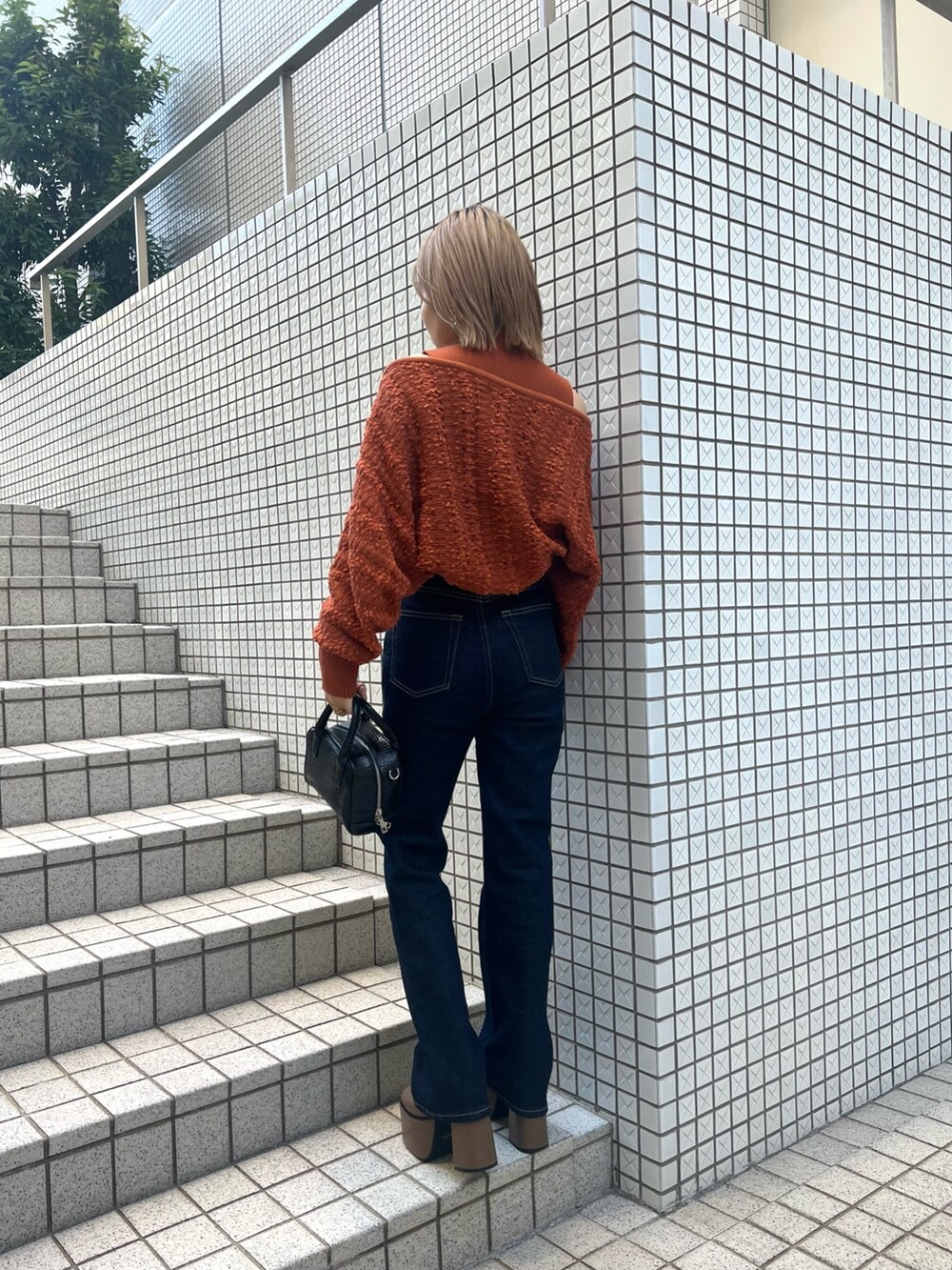 オレンジ系のカーディガン/ボレロ、ブルー系のデニムパンツ、ブラウン系のブーツを着用したレディースの夏コーディネートの6枚目の写真