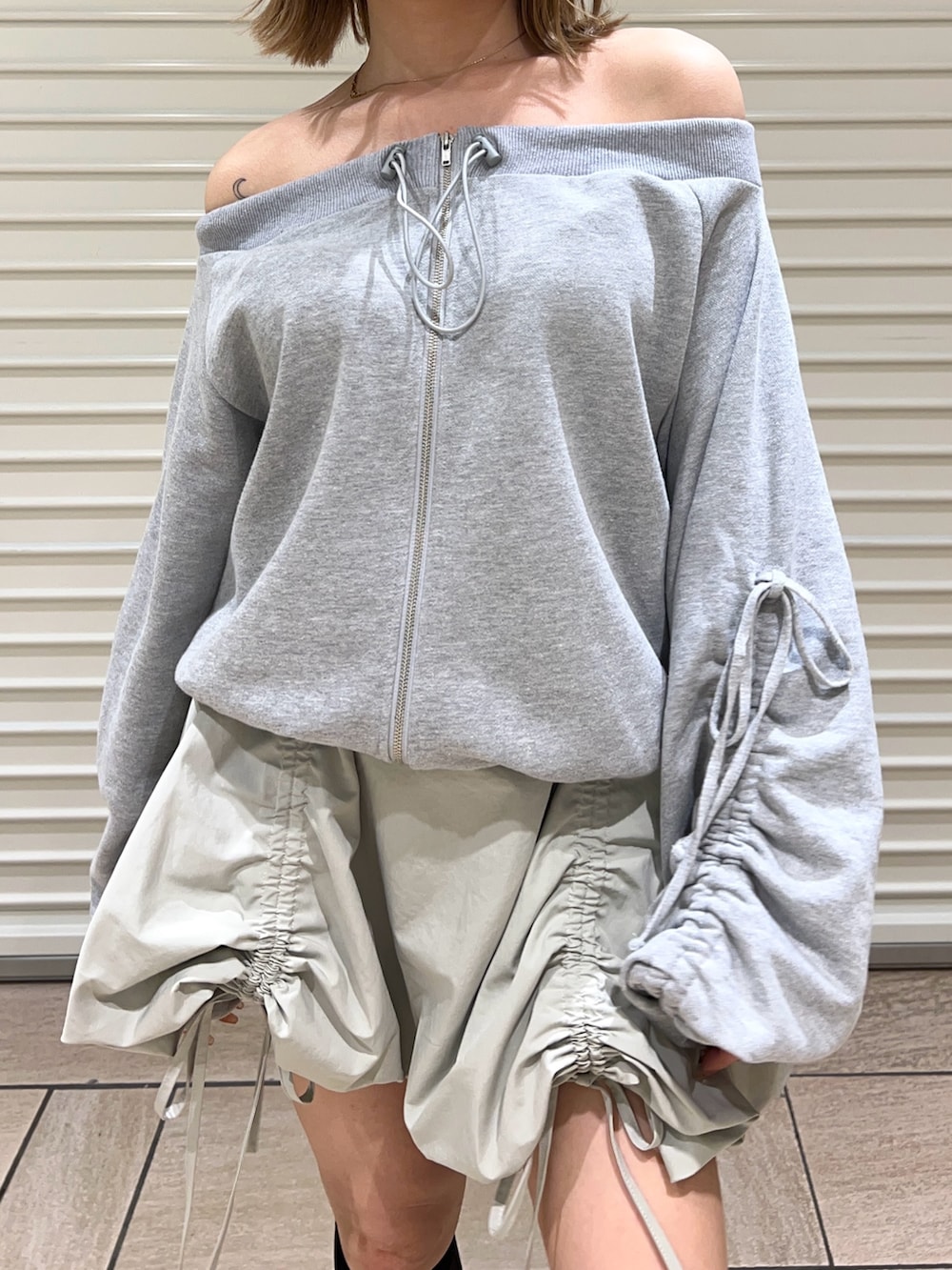 グリーン系のスカート、グレー系のスウェットを着用したレディースの春コーディネートの6枚目の写真