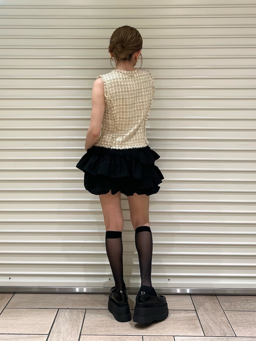 ベージュ系のベスト、ブラック系のその他パンツを着用したレディースの夏コーディネートの3枚目の写真