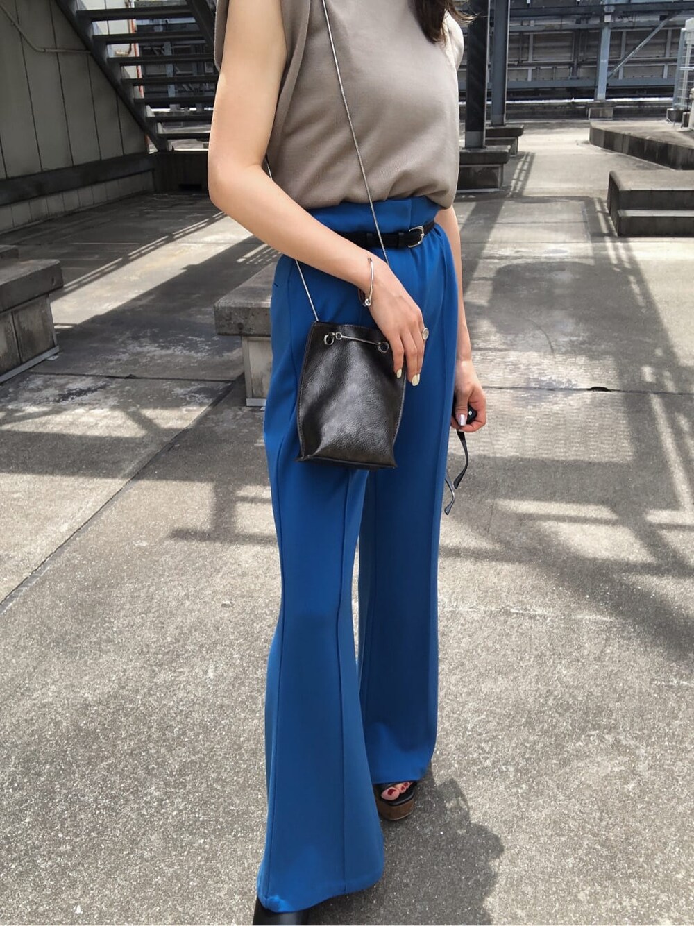 ブルー系のスラックス、ブラック系のサンダル、ベージュ系のタンクトップを着用したレディースの夏コーディネートの5枚目の写真