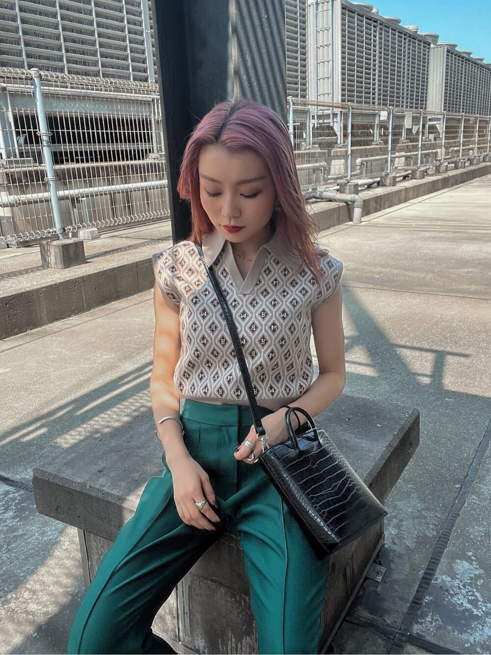 ベージュ系のニット/セーター、グリーン系のスラックスを着用したレディースの夏コーディネートの5枚目の写真