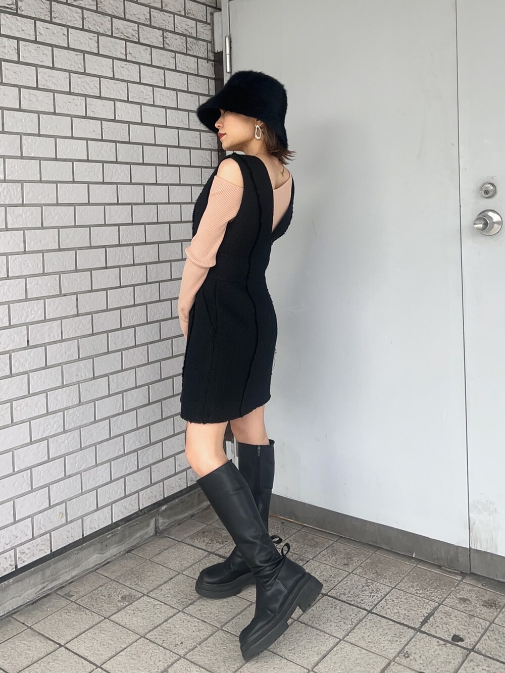 ベージュ系のニット/セーター、ブラック系のワンピース、ブラック系のブーツを着用したレディースの冬コーディネートの2枚目の写真