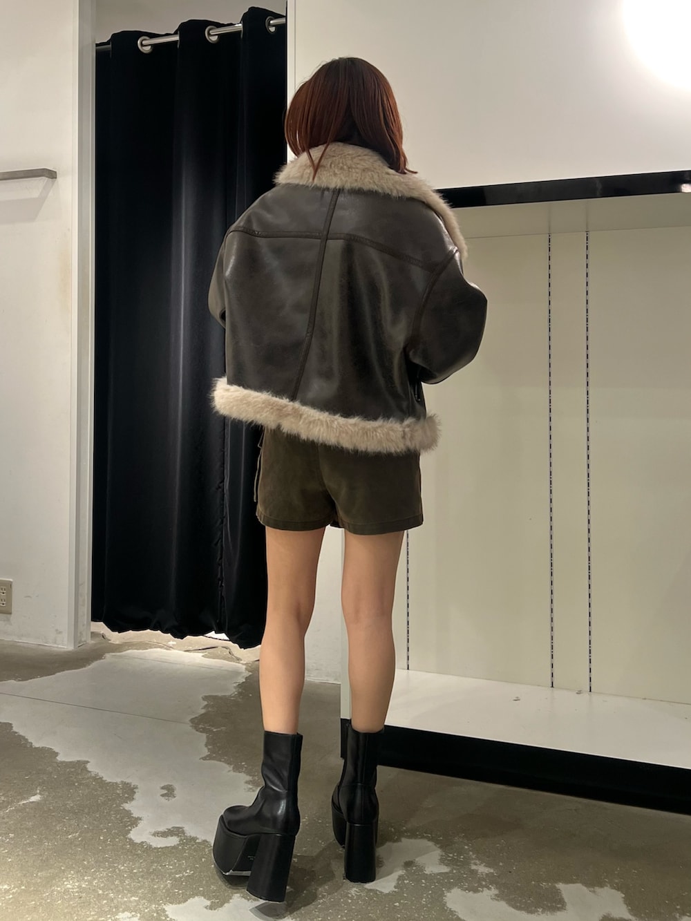 ブラウン系のムートンコート、ホワイト系のニット/セーター、ブラウン系のその他パンツを着用したレディースの秋コーディネートの3枚目の写真