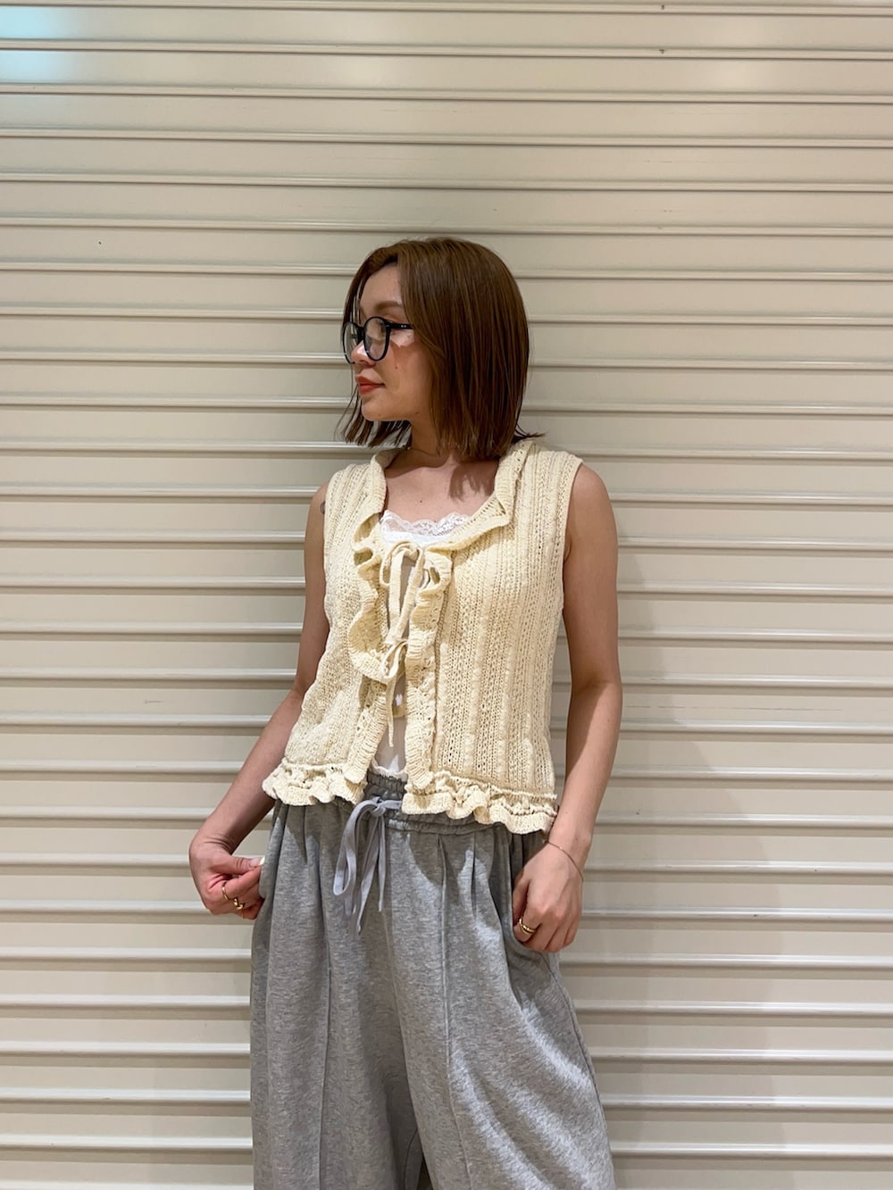 ホワイト系のニット/セーター、グレー系のスウェットパンツを着用したレディースの夏コーディネートの4枚目の写真
