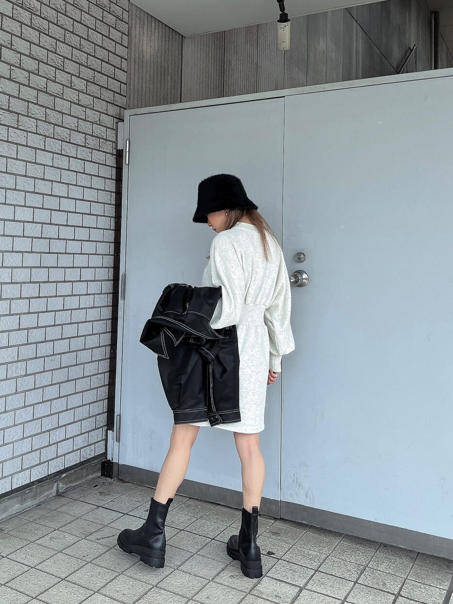 ホワイト系のワンピース、ブラック系のブーツ、ブラック系のブルゾンを着用したレディースの秋コーディネートの2枚目の写真