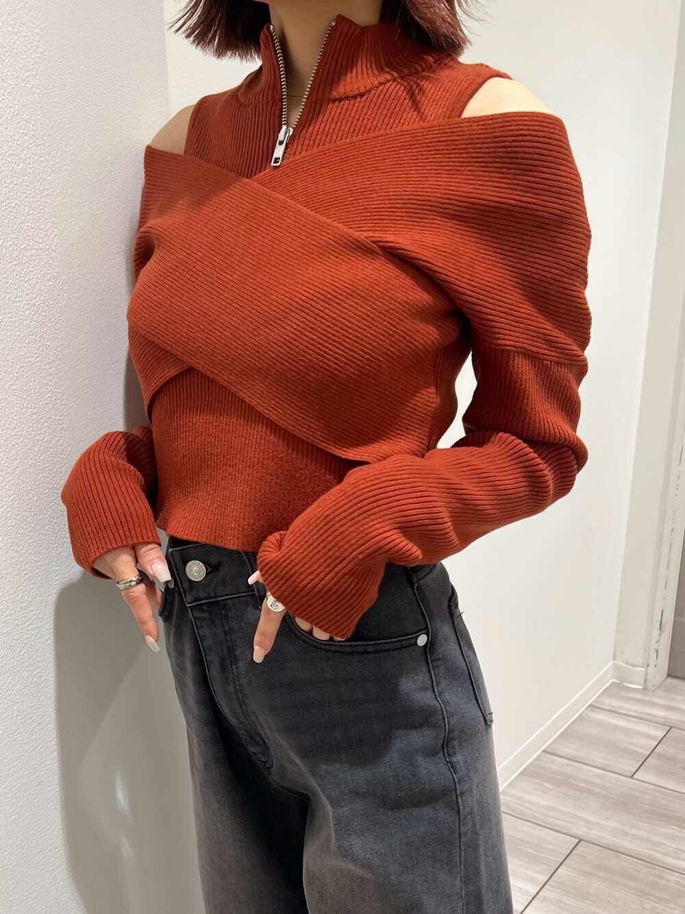 オレンジ系のニット/セーター、グレー系のデニムパンツを着用したレディースの冬コーディネートの7枚目の写真