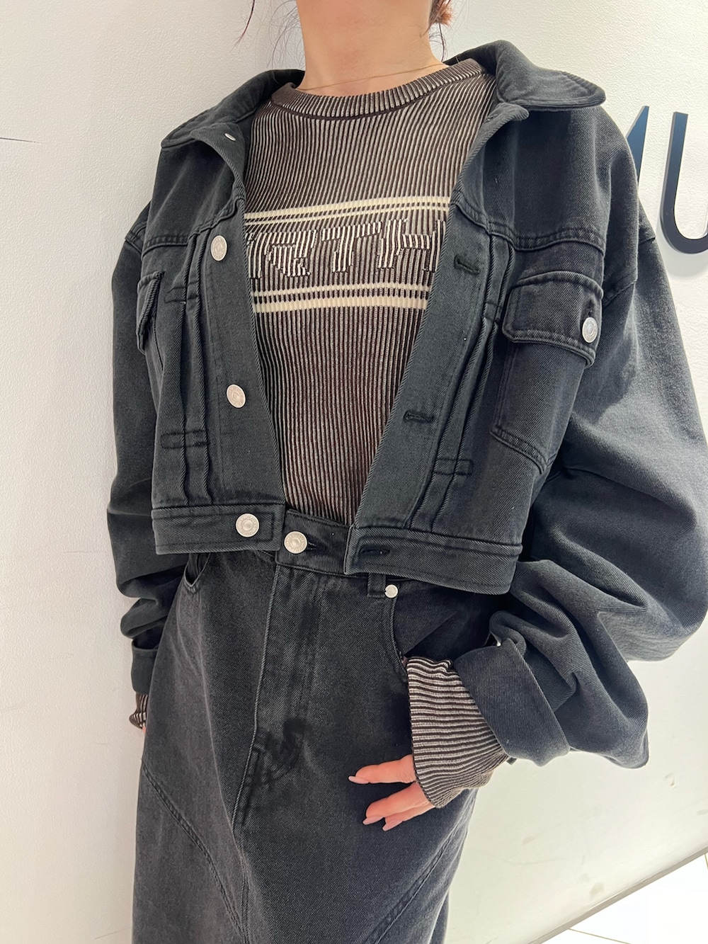 ブラック系のブーツ、ブラック系のデニムスカート、ブラック系のデニムジャケットを着用したレディースの春コーディネートの6枚目の写真