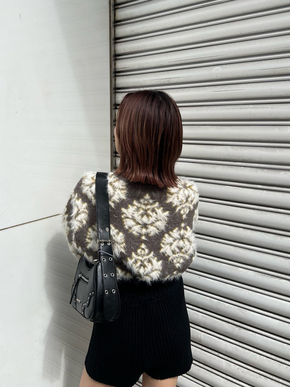 ブラウン系のニット/セーター、ブラック系のハンドバッグ、ブラック系のその他パンツを着用したレディースの秋コーディネートの6枚目の写真