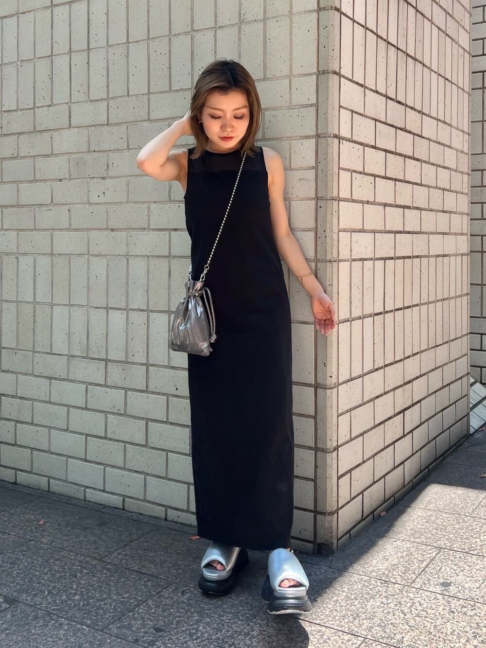 ブラック系のワンピース、シルバー系のサンダル、ブラック系のショルダーバッグを着用したレディースの夏コーディネートの3枚目の写真