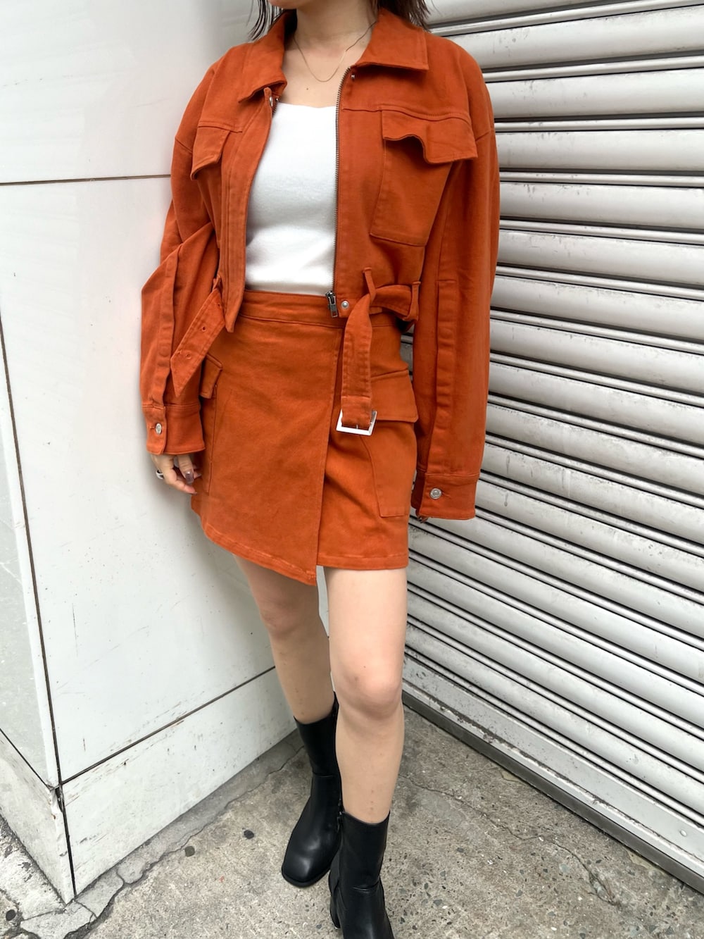 ホワイト系のニット/セーター、オレンジ系のデニムジャケット、オレンジ系のスカートを着用したレディースの夏コーディネートの7枚目の写真