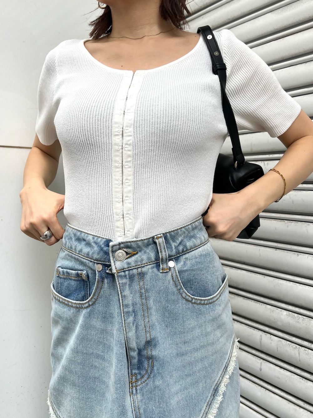 ホワイト系のニット/セーター、ブルー系のデニムスカート、ブラック系のハンドバッグを着用したレディースの夏コーディネートの7枚目の写真