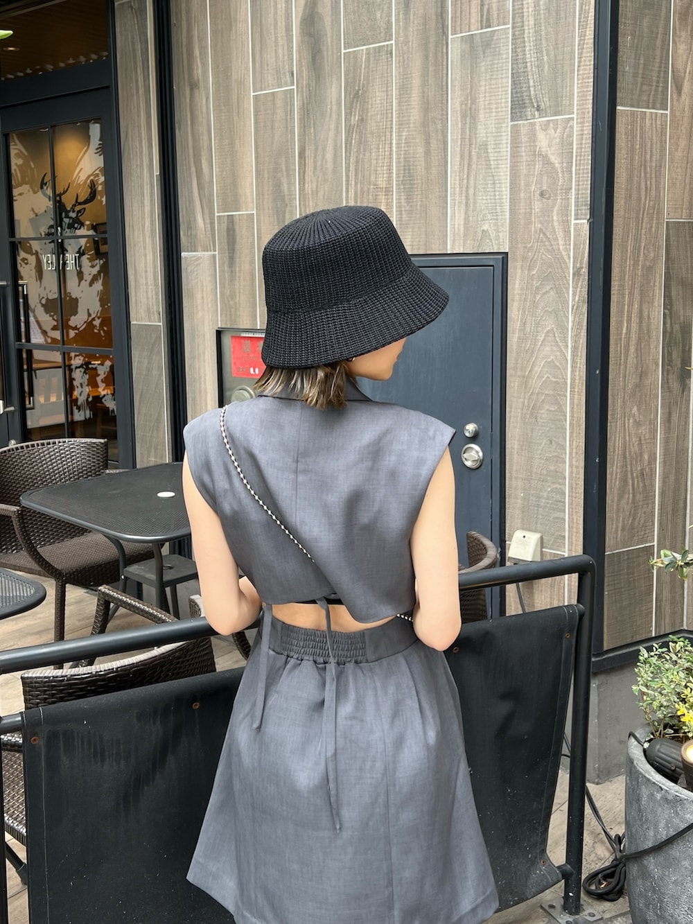 グレー系のワンピース、ブラック系のショルダーバッグ、ブラック系のブーツを着用したレディースの春コーディネートの5枚目の写真