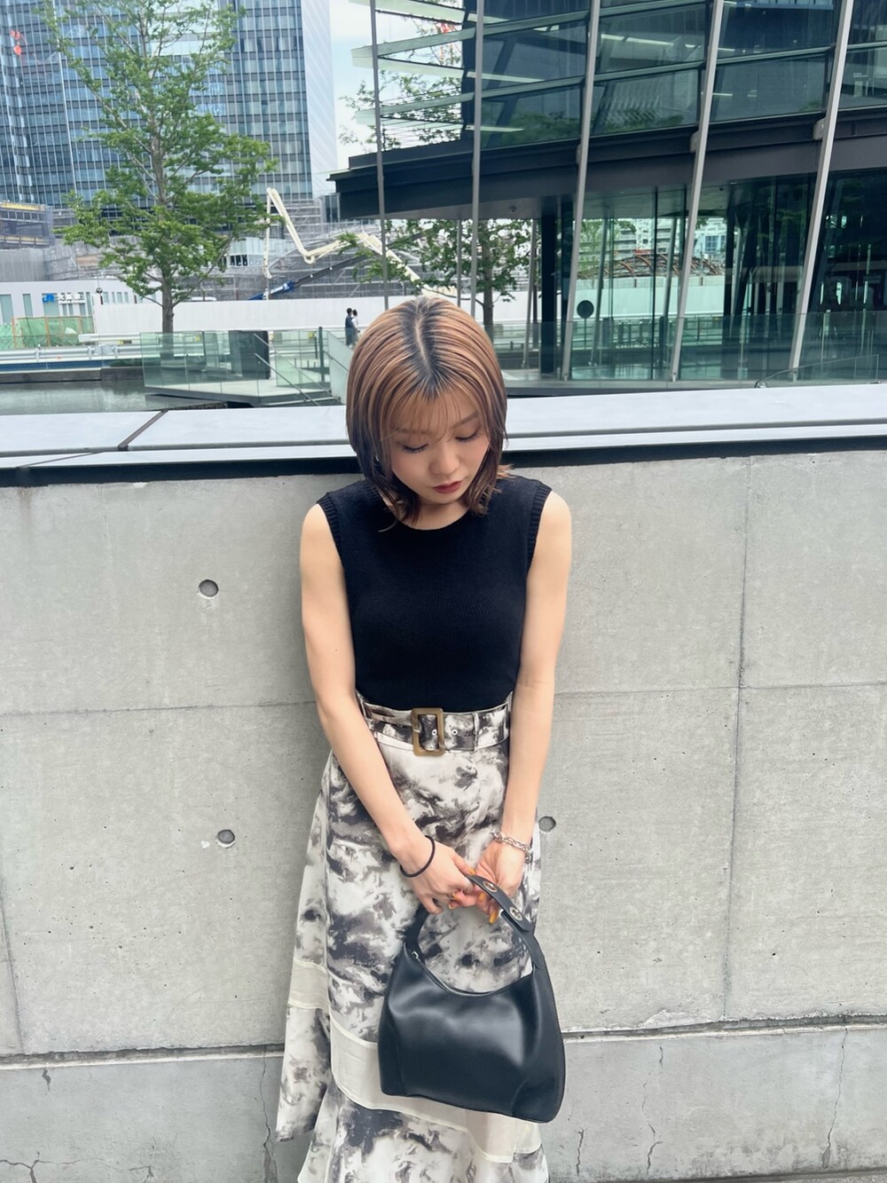 ブラック系のサンダル、ブラック系のハンドバッグ、その他のスカートを着用したレディースの夏コーディネートの5枚目の写真