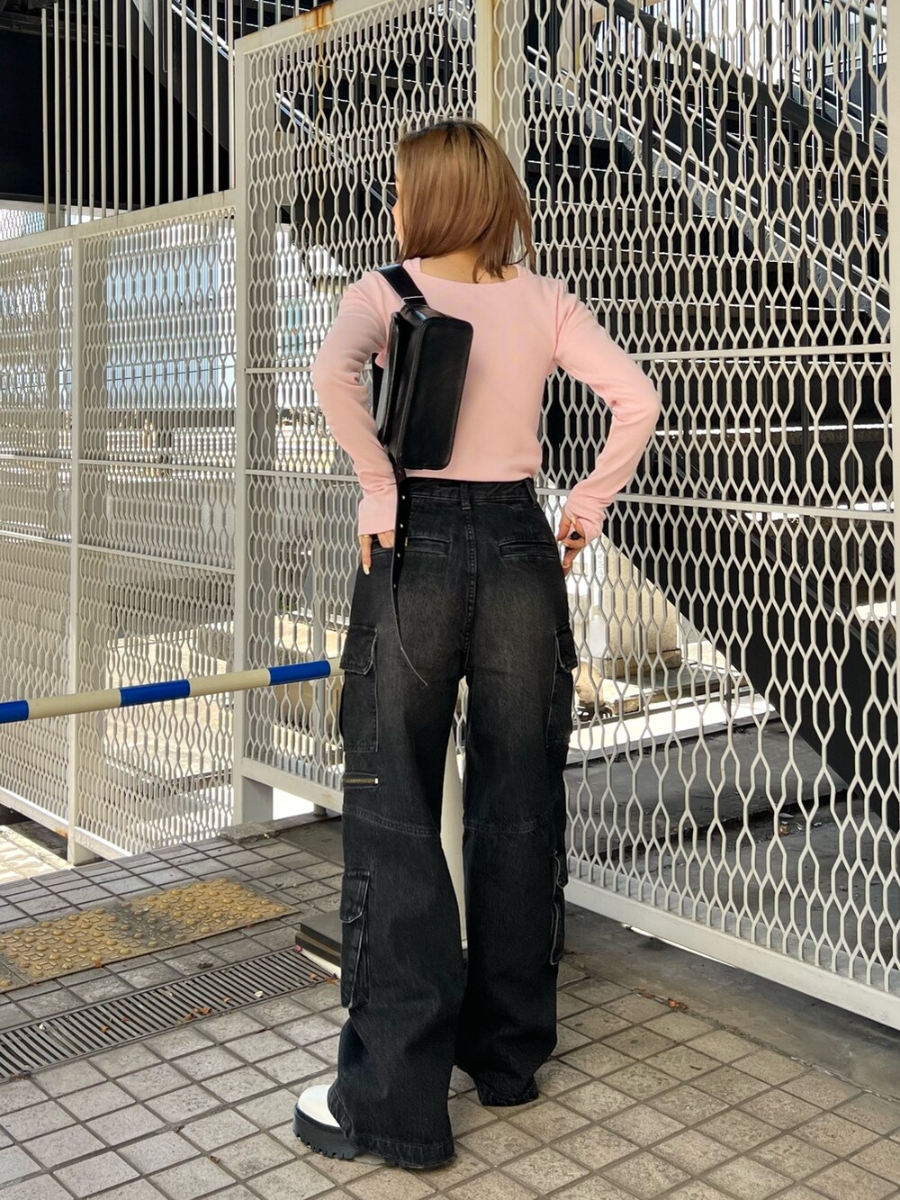 ピンク系のTシャツ/カットソー、ブラック系のデニムパンツ、ホワイト系のブーツを着用したレディースの冬コーディネートの3枚目の写真