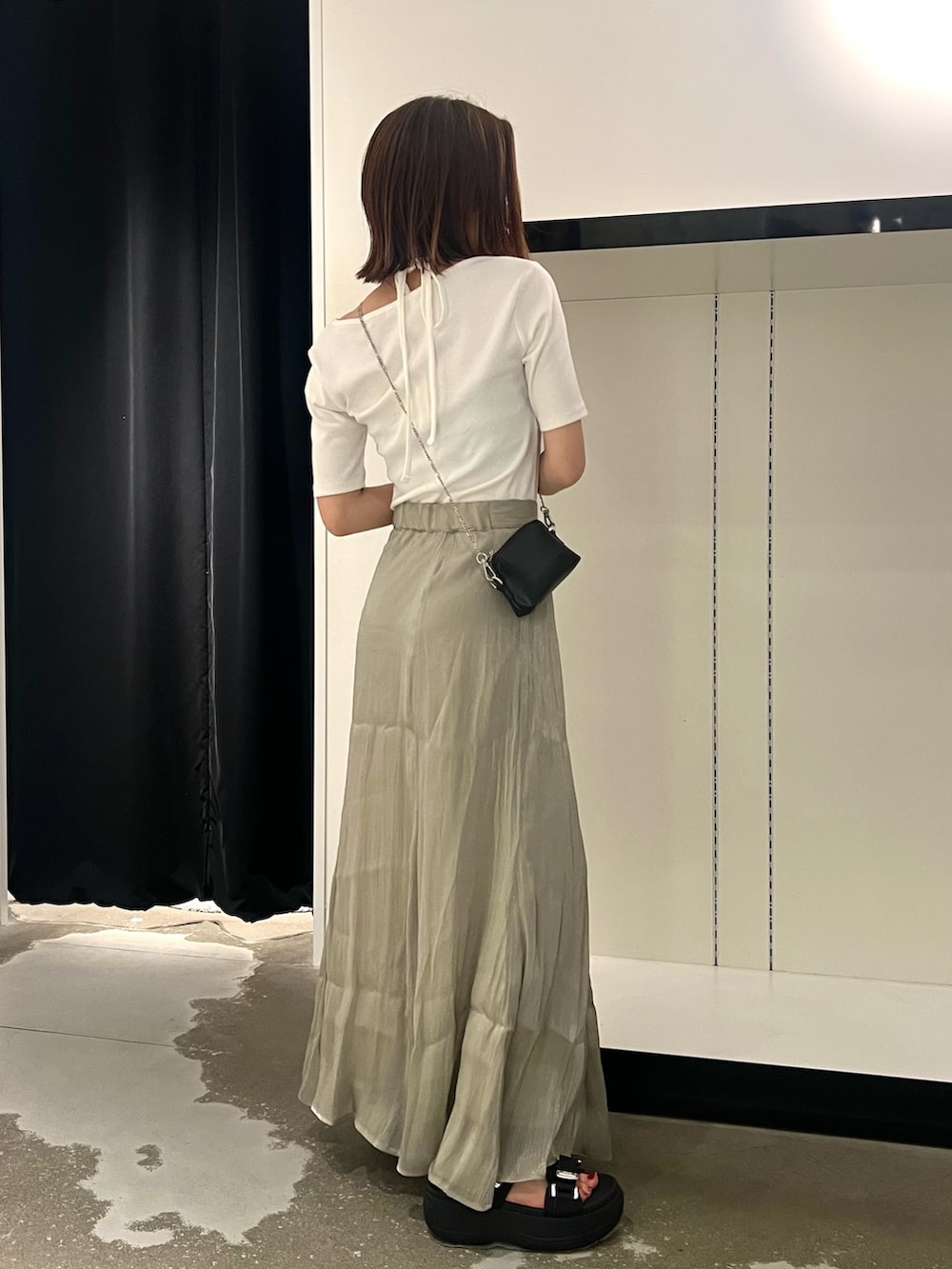 ブラック系のサンダル、ブラック系のショルダーバッグ、ホワイト系のTシャツ/カットソーを着用したレディースの夏コーディネートの3枚目の写真