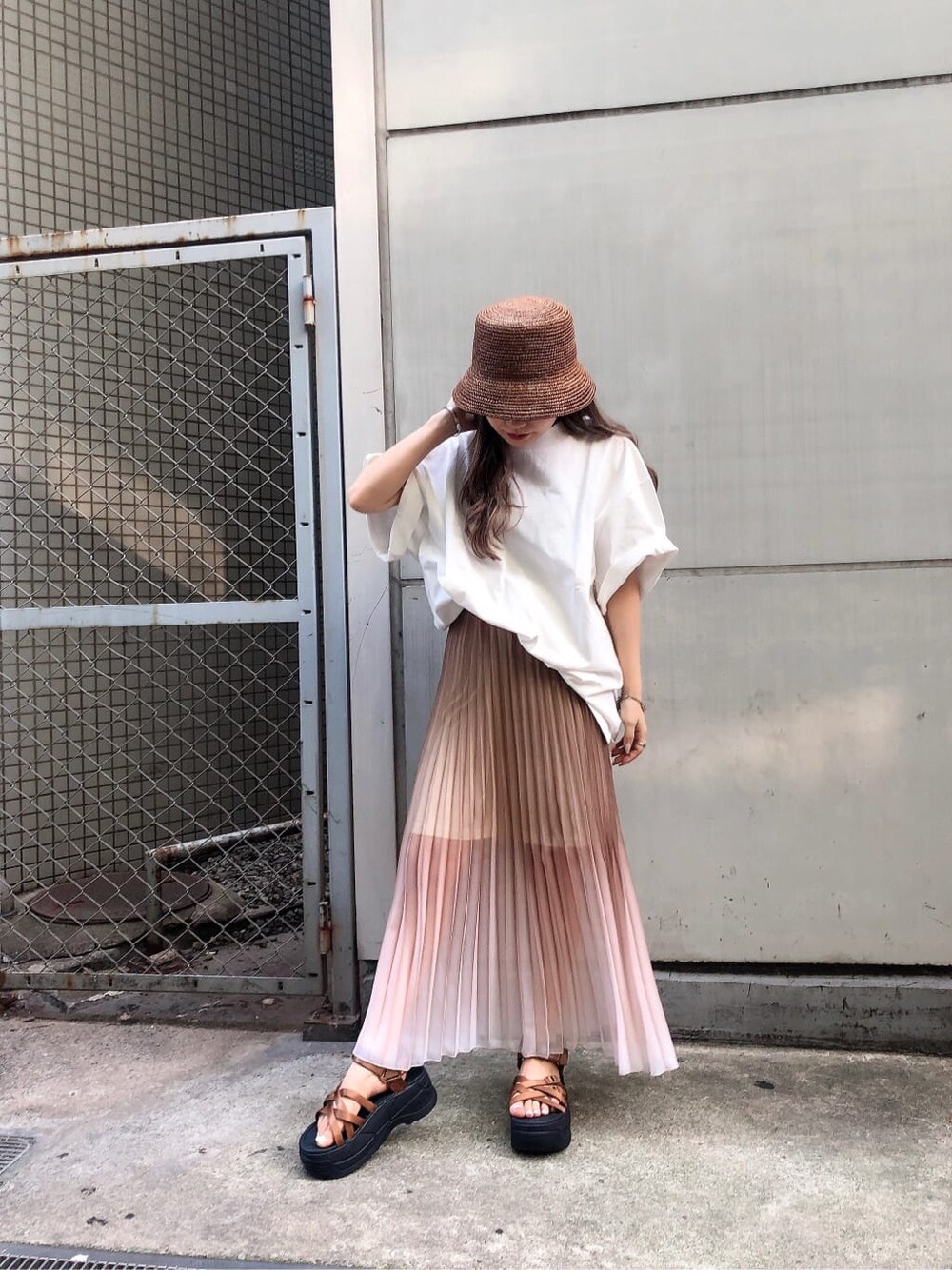 ブラック系のサンダル、ホワイト系のTシャツ/カットソー、ベージュ系のスカートを着用したレディースの夏コーディネートの2枚目の写真