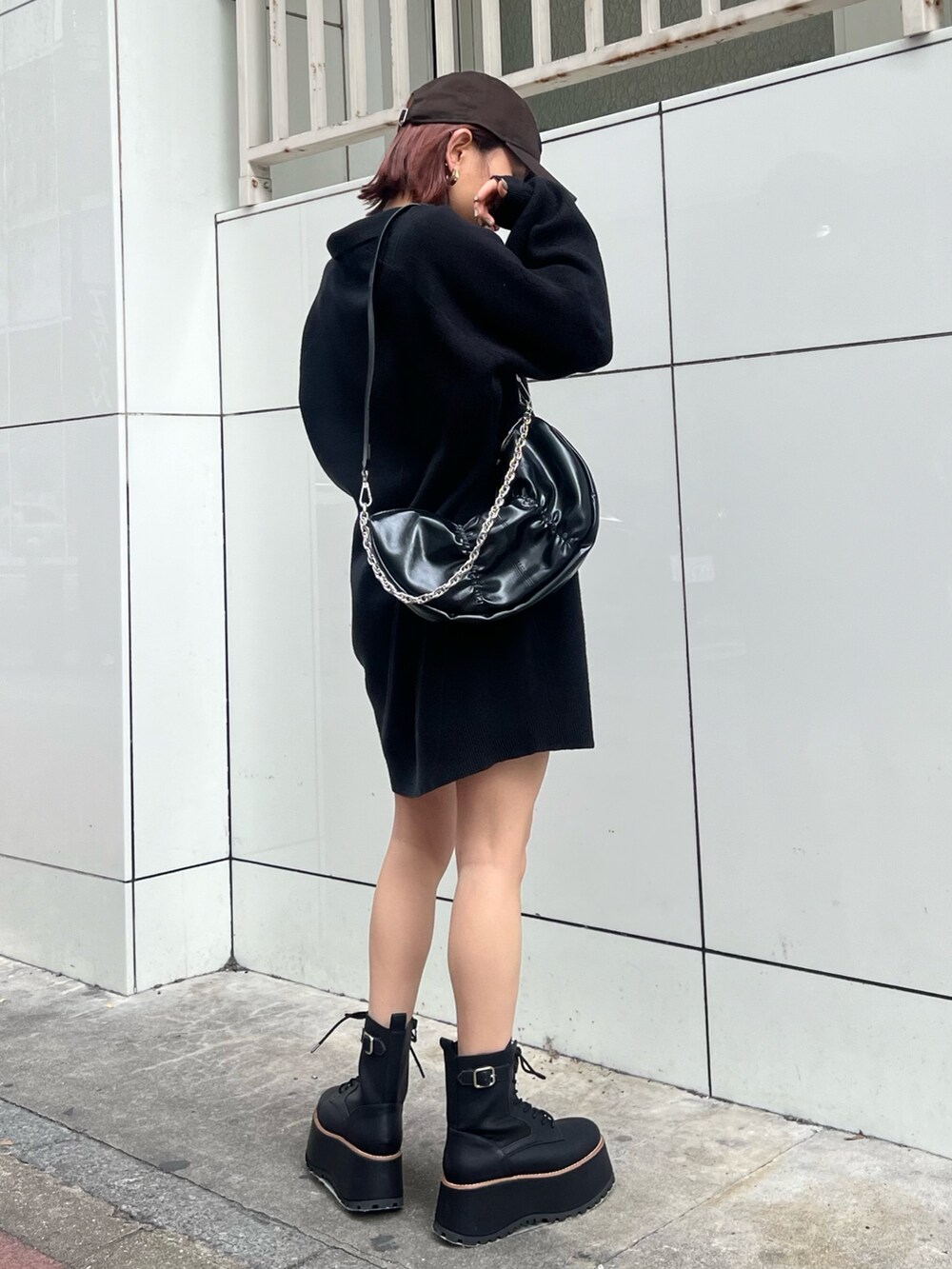 ブラック系のショルダーバッグ、ブラック系のブーツ、ブラック系のワンピースを着用したレディースの冬コーディネートの2枚目の写真