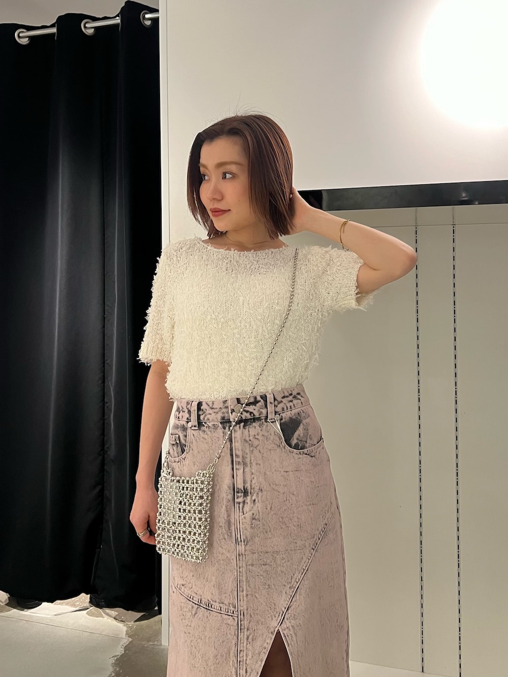 ホワイト系のニット/セーター、ピンク系のデニムスカート、ブラック系のブーツを着用したレディースの春コーディネートの5枚目の写真