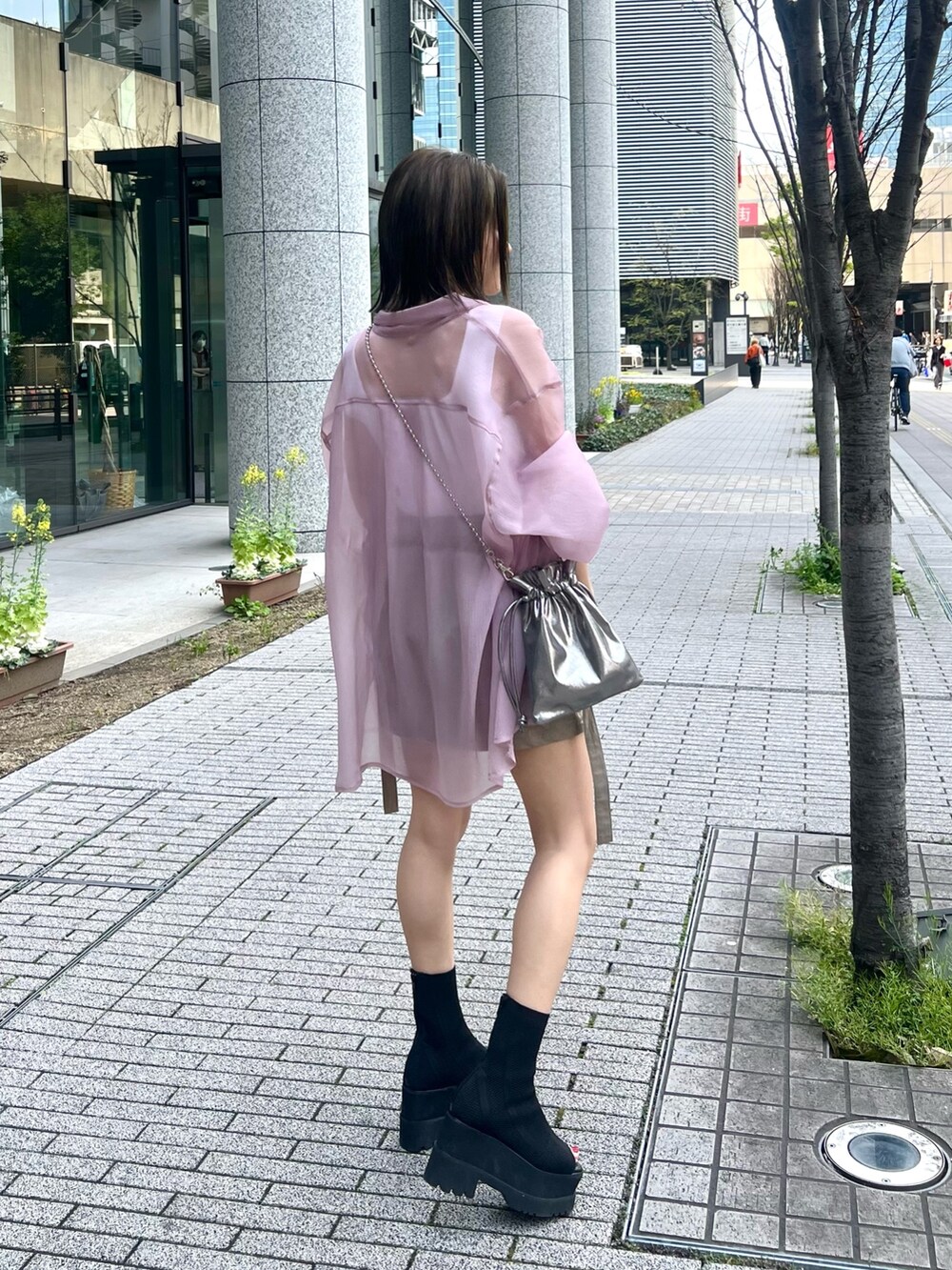 ピンク系のシャツ/ブラウス、ホワイト系のニット/セーター、グレー系のショルダーバッグを着用したレディースの春コーディネートの2枚目の写真