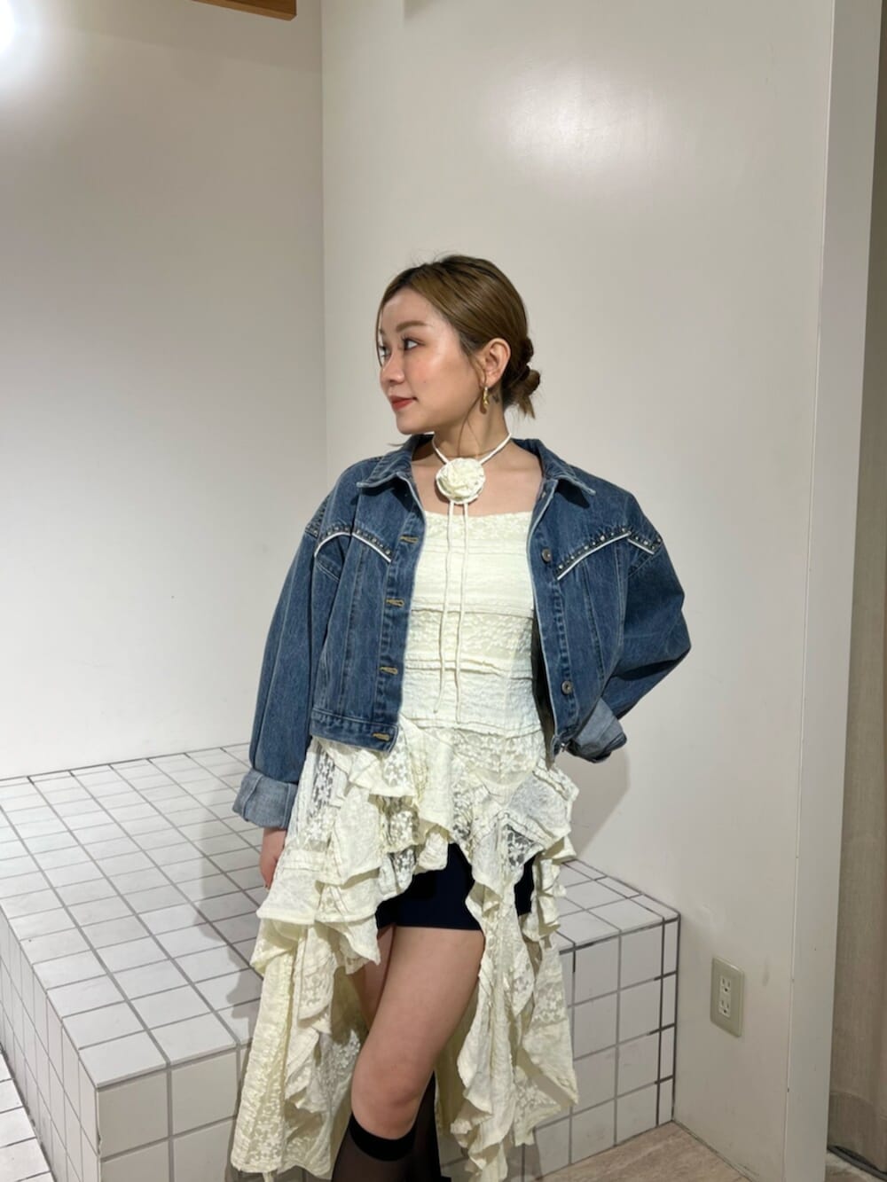ブルー系のデニムジャケット、イエロー系のワンピースを着用したレディースの春コーディネートの4枚目の写真