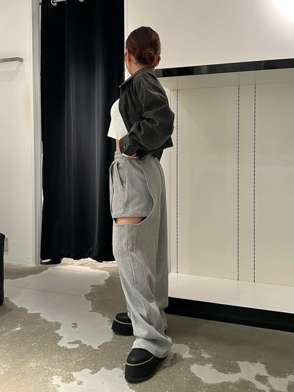 ブラック系のブルゾン、ホワイト系のTシャツ/カットソー、グレー系のスウェットパンツを着用したレディースの秋コーディネートの2枚目の写真