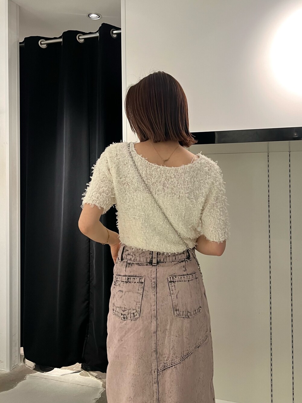 ホワイト系のニット/セーター、ピンク系のデニムスカート、ブラック系のブーツを着用したレディースの春コーディネートの6枚目の写真