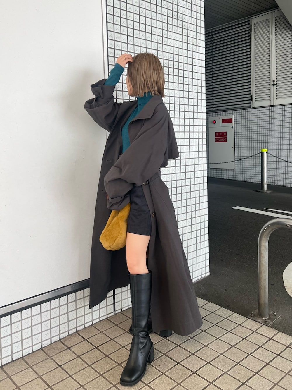 グレー系のトレンチコート、ブルー系のニット/セーター、ブラック系のその他パンツを着用したレディースの秋コーディネートの4枚目の写真