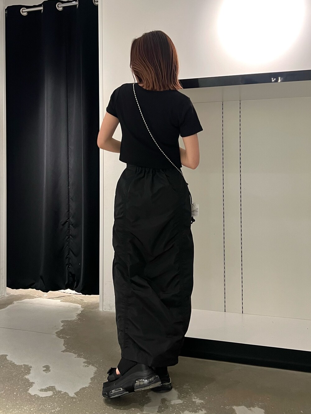 ブラック系のTシャツ/カットソー、ブラック系のサンダル、ブラック系のスカートを着用したレディースの春コーディネートの3枚目の写真