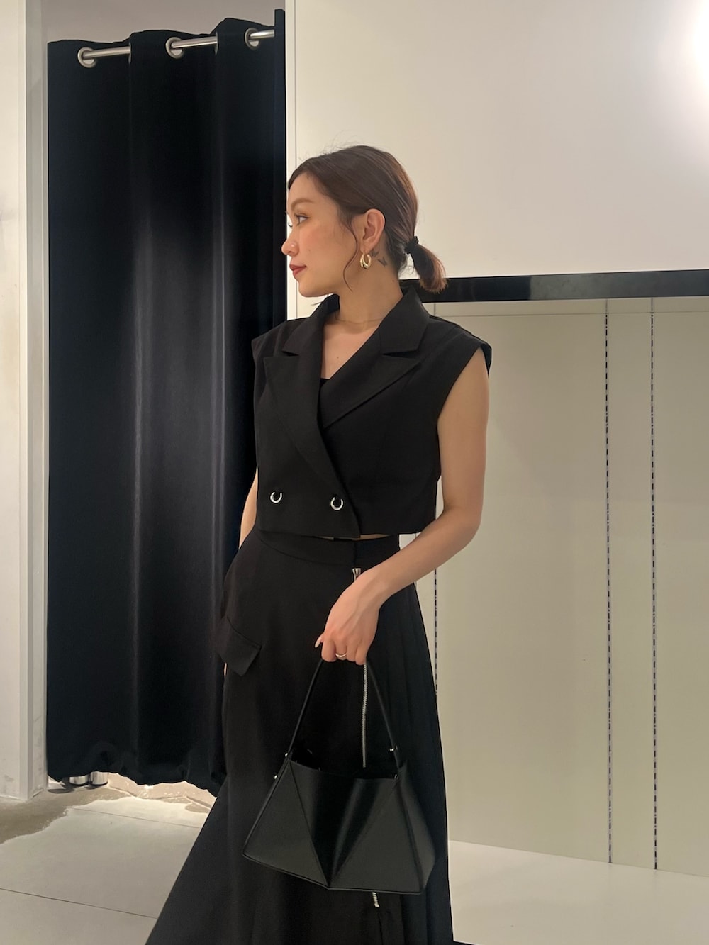 ブラック系のワンピース、ブラック系のサンダル、ブラック系のハンドバッグを着用したレディースの夏コーディネートの5枚目の写真