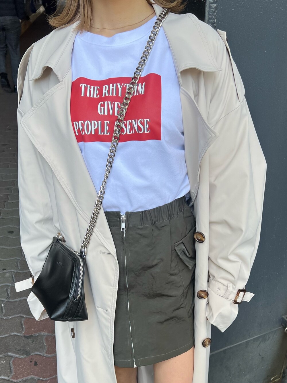 ブラック系のブーツ、ホワイト系のトレンチコート、ホワイト系のTシャツ/カットソーを着用したレディースの春コーディネートの7枚目の写真