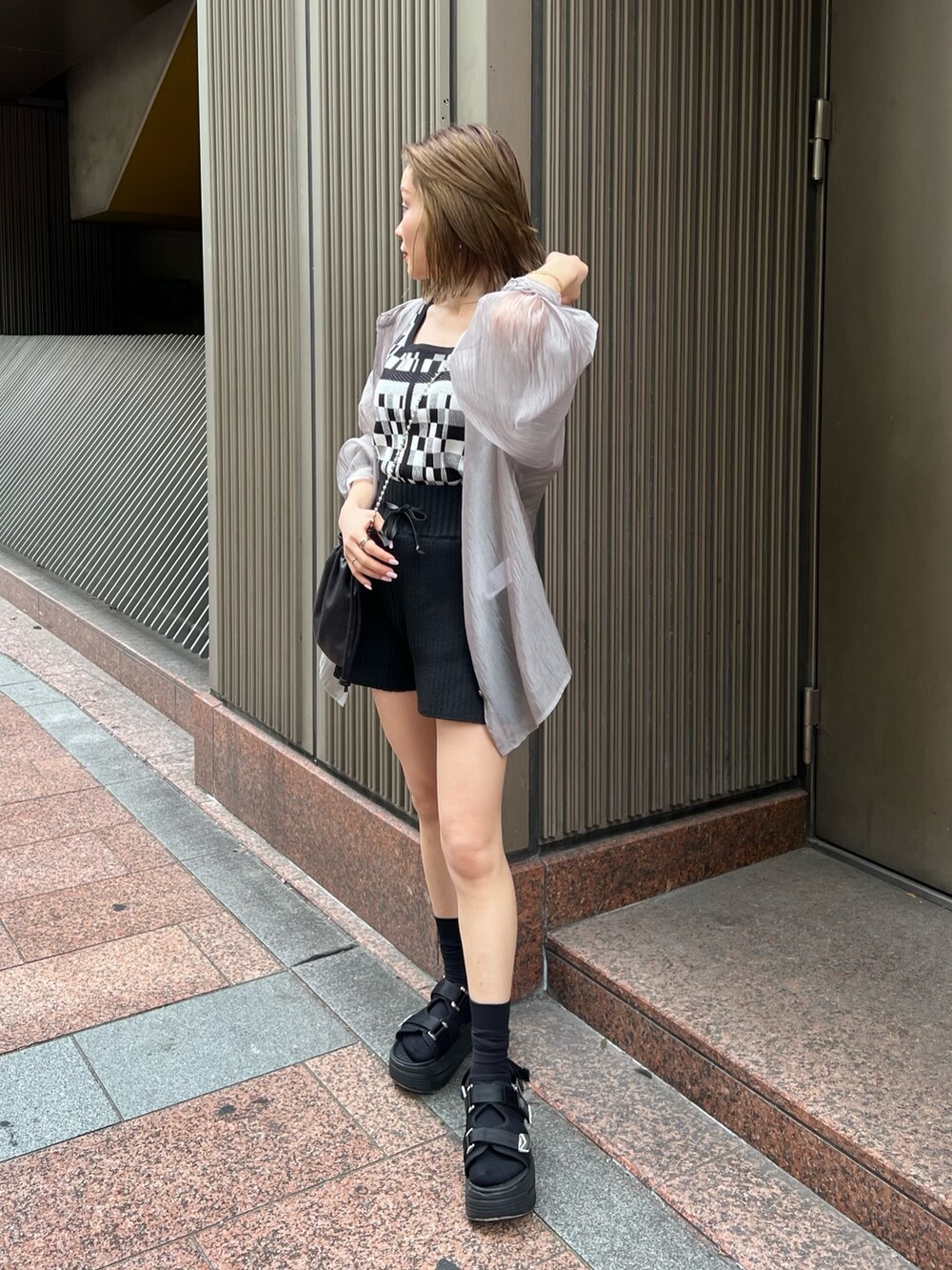 ブラック系のタンクトップ、ブラック系のその他パンツ、ブラック系のショルダーバッグを着用したレディースの春コーディネートの2枚目の写真