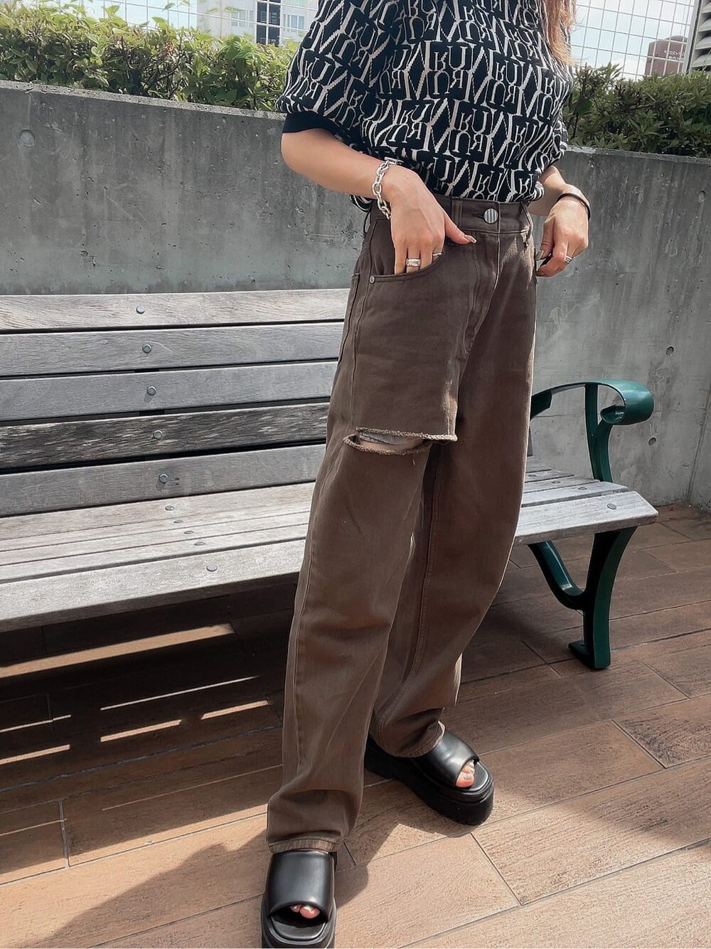 ブラウン系のデニムパンツ、ブラック系のニット/セーターを着用したレディースの夏コーディネートの4枚目の写真