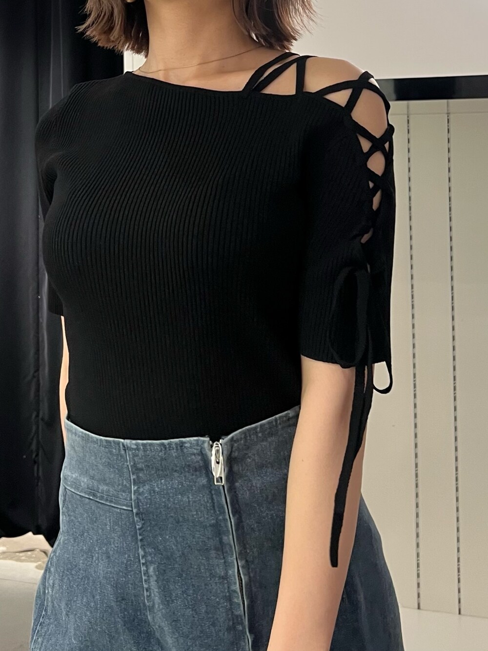 ブルー系のデニムスカート、ブラック系のニット/セーター、ブラック系のサンダルを着用したレディースの夏コーディネートの7枚目の写真