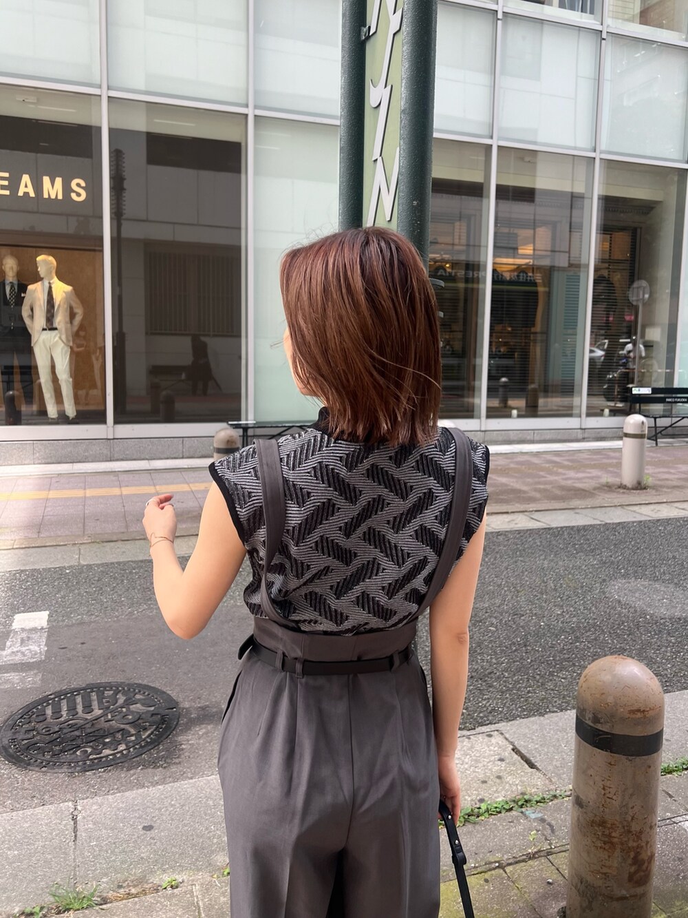 ブラック系のニット/セーター、グレー系のその他パンツ、ブラック系のハンドバッグを着用したレディースの夏コーディネートの6枚目の写真