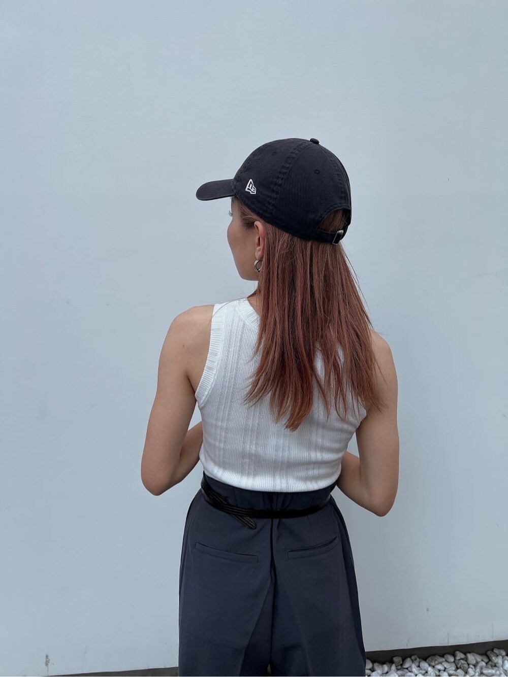 ホワイト系のタンクトップ、グレー系のスラックス、ブラック系のベルトを着用したレディースの夏コーディネートの8枚目の写真