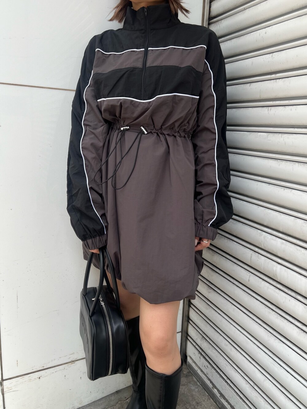 ブラック系のボストンバッグ、ブラック系のワンピース、ブラック系のブーツを着用したレディースの夏コーディネートの7枚目の写真