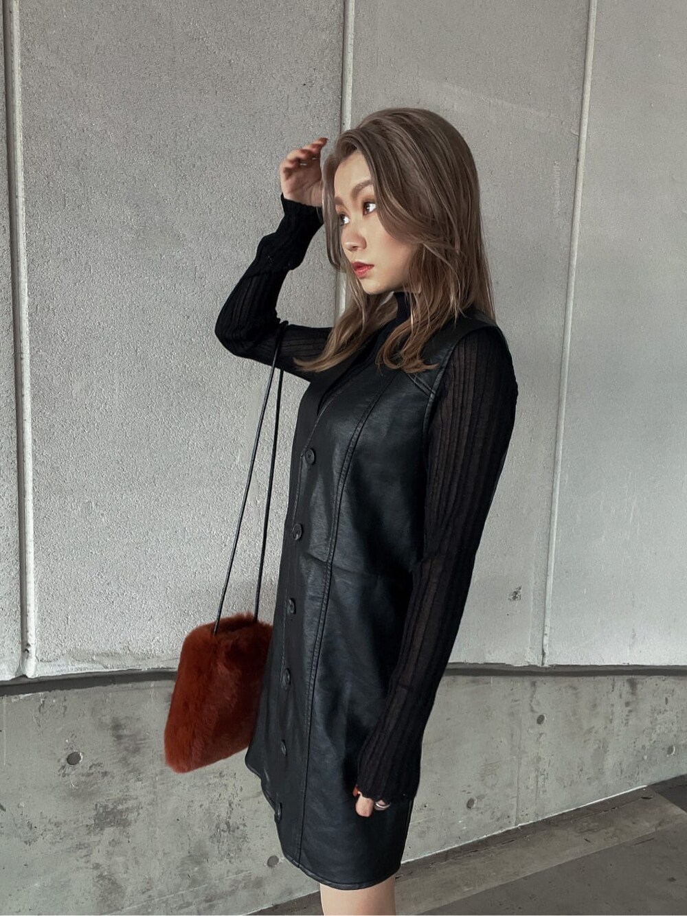 ブラック系のニット/セーター、ブラウン系のショルダーバッグ、ブラック系のワンピースを着用したレディースの秋コーディネートの5枚目の写真