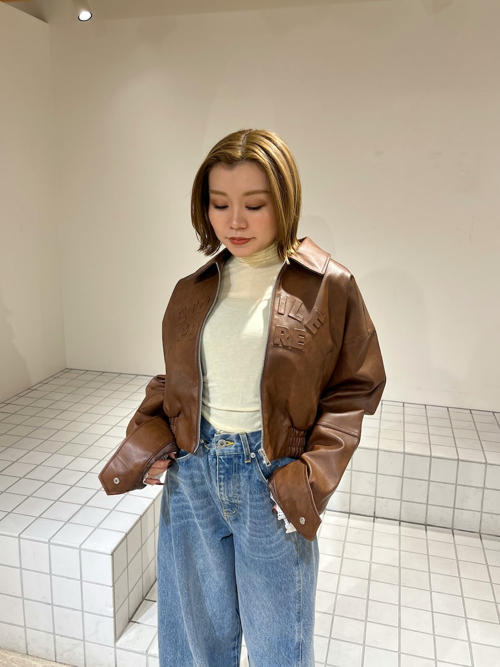 イエロー系のTシャツ/カットソー、ブルー系のその他パンツ、ブラウン系のブルゾンを着用したレディースの冬コーディネートの5枚目の写真